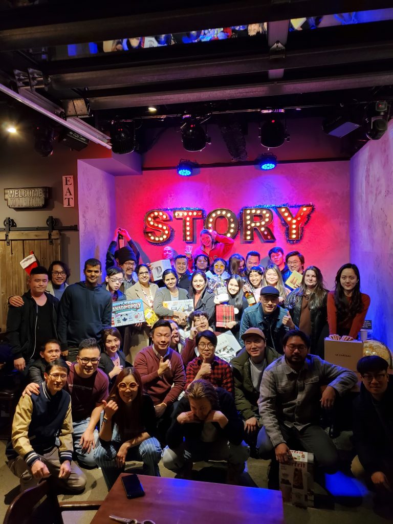 The whole Story Cafe team with their gifts under the STORY sign, 2021