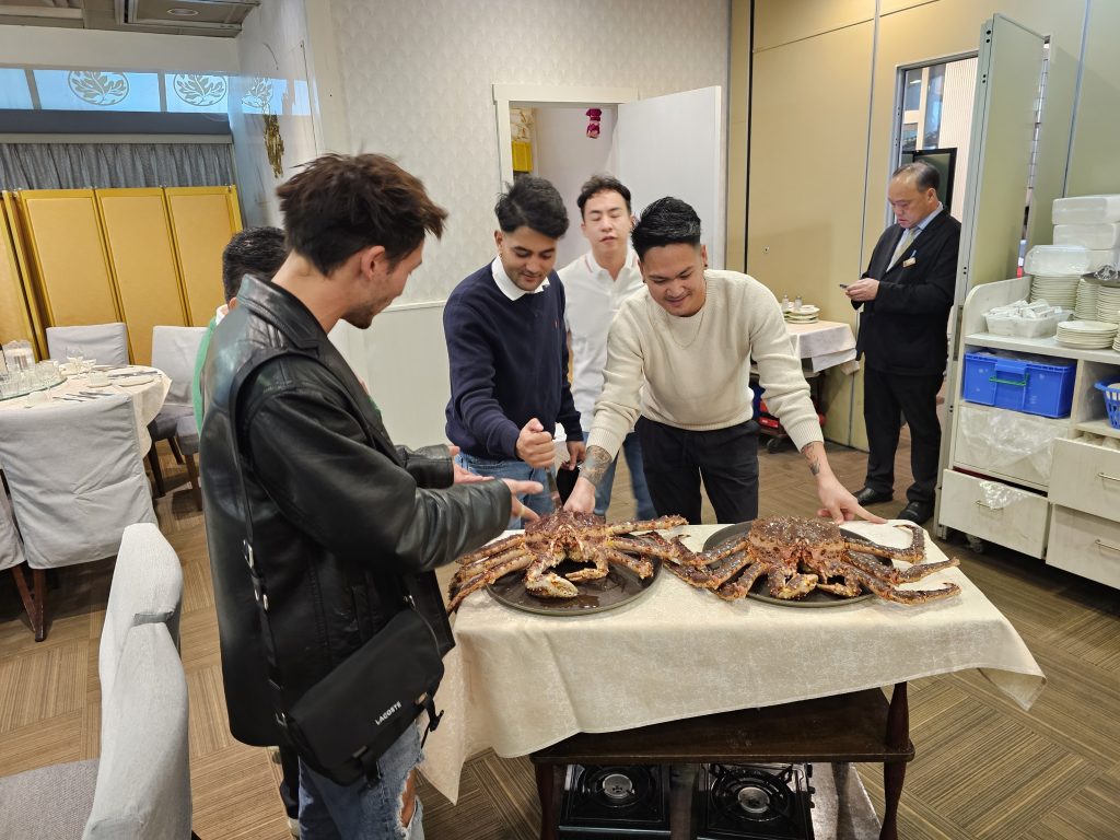 Team members admiring two king crabs at the 2024 Christmas dinner