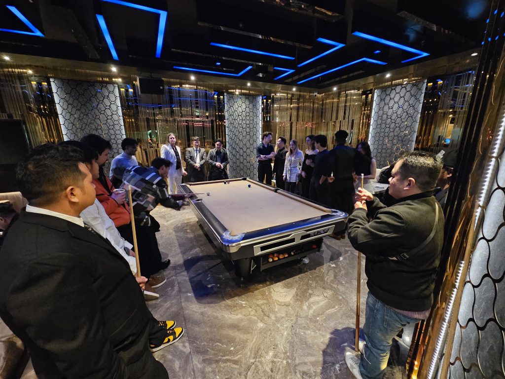 Team members gathered around the pool table