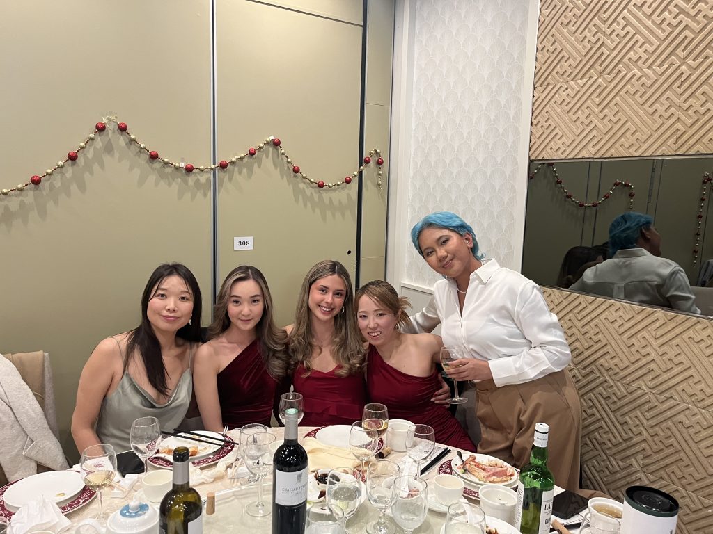 Five team members posing together at their table