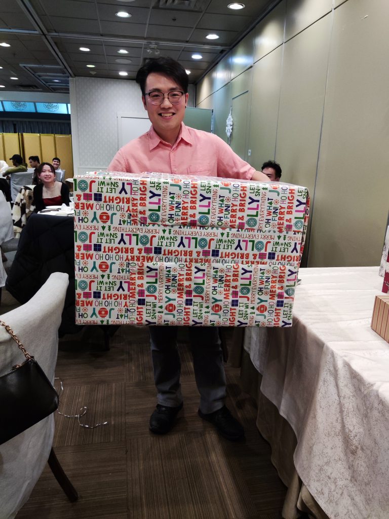A team member holding a large wrapped present