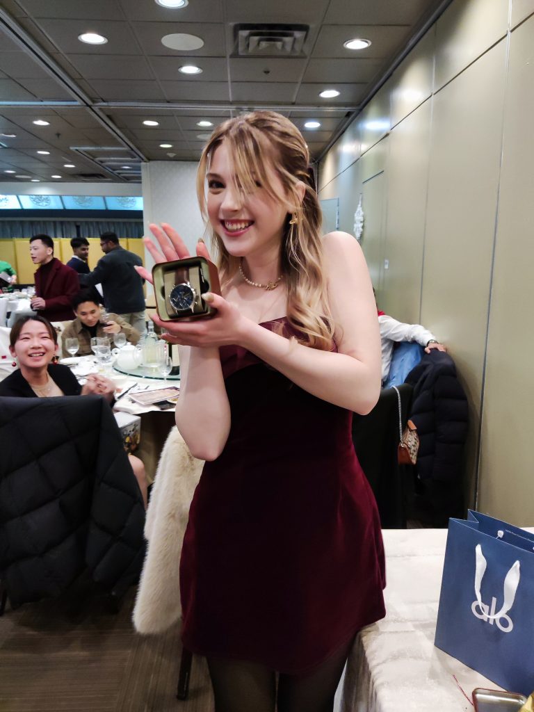 A team member showing off a new watch from the gift exchange