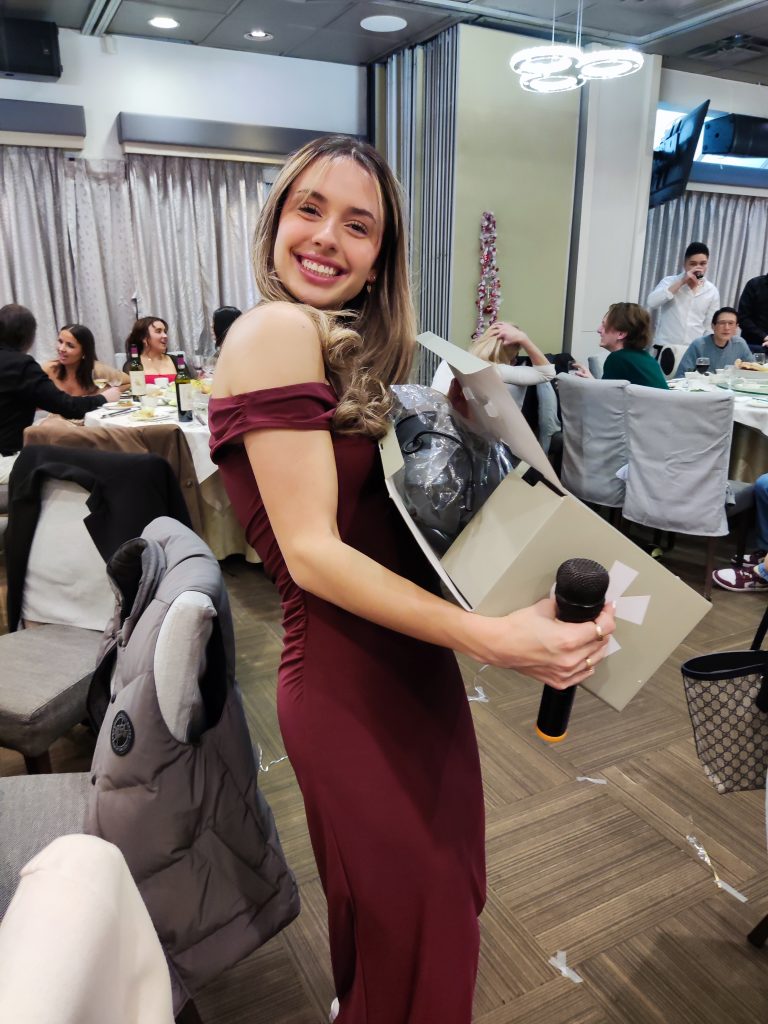 A team member smiling with her gift-exchange prize