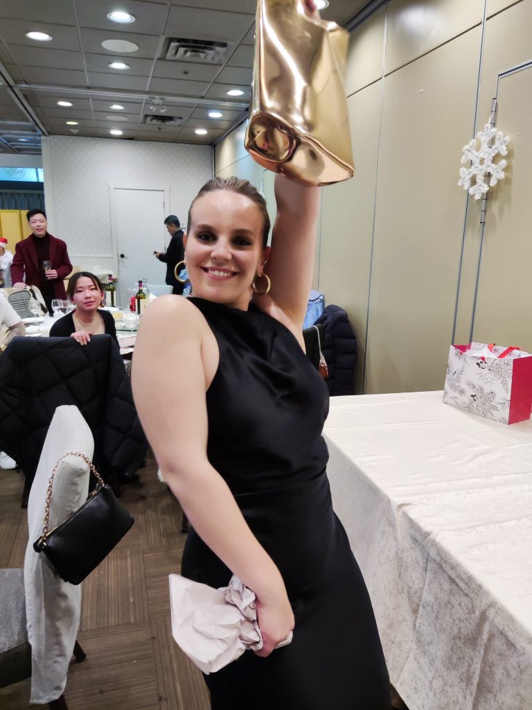 A team member celebrating with a gold gift bag