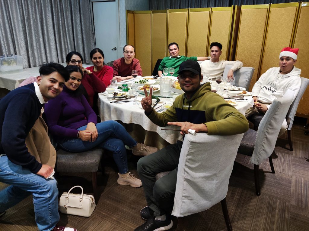 Team members gathered around a table at the 2024 Christmas party